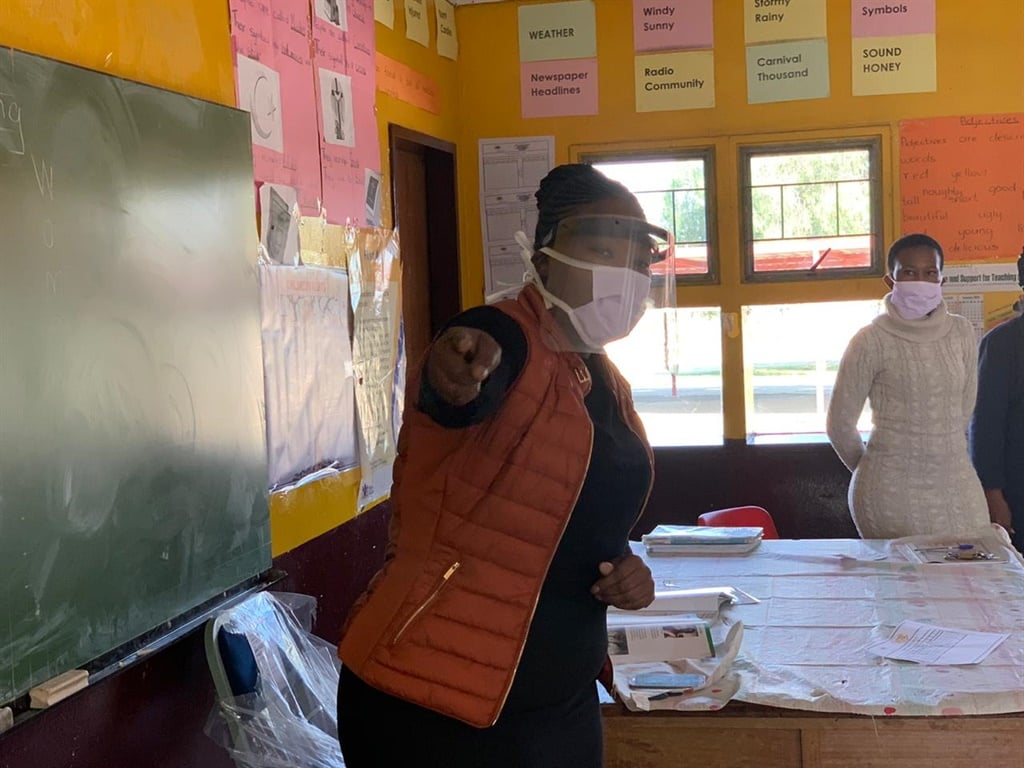 A teacher at a primary school wearing her PPE, a mask and a shield. 