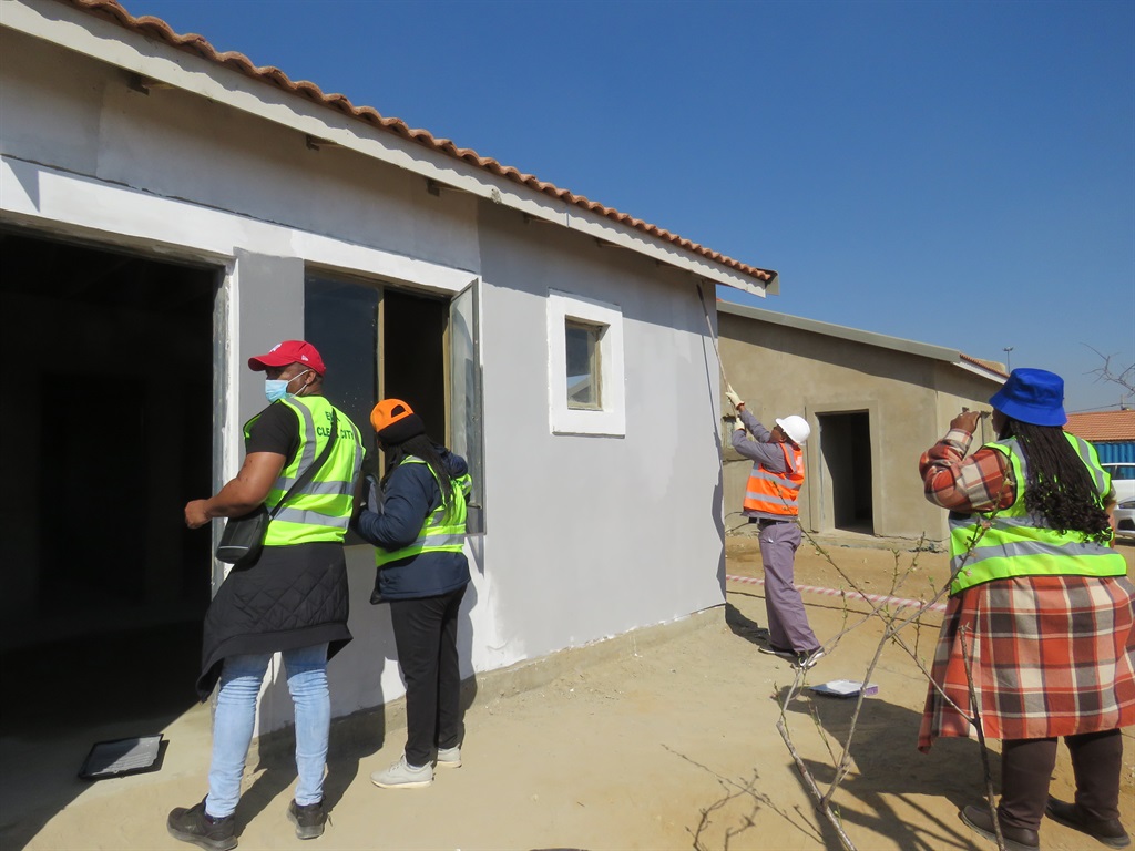 Ekurhuleni housing officials and the mayor painting a house ekasi.  Photo by Ntebatse Masipa