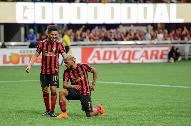 Atlanta United's Josef Martinez kneels after scoring a goal as teammate Gonzalo "Pity" Martínez congratulates him (Getty Images)