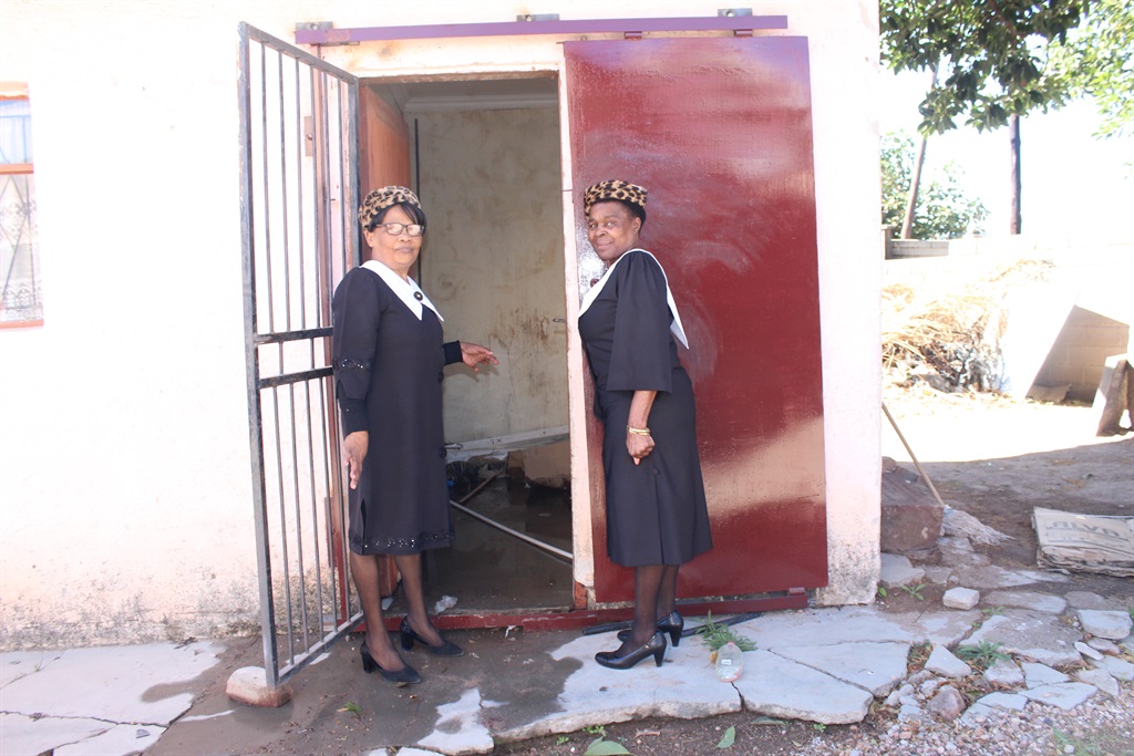 Church members Mahadi Matjutla (left) and Mpelege Monyai at the security door the criminals broke.