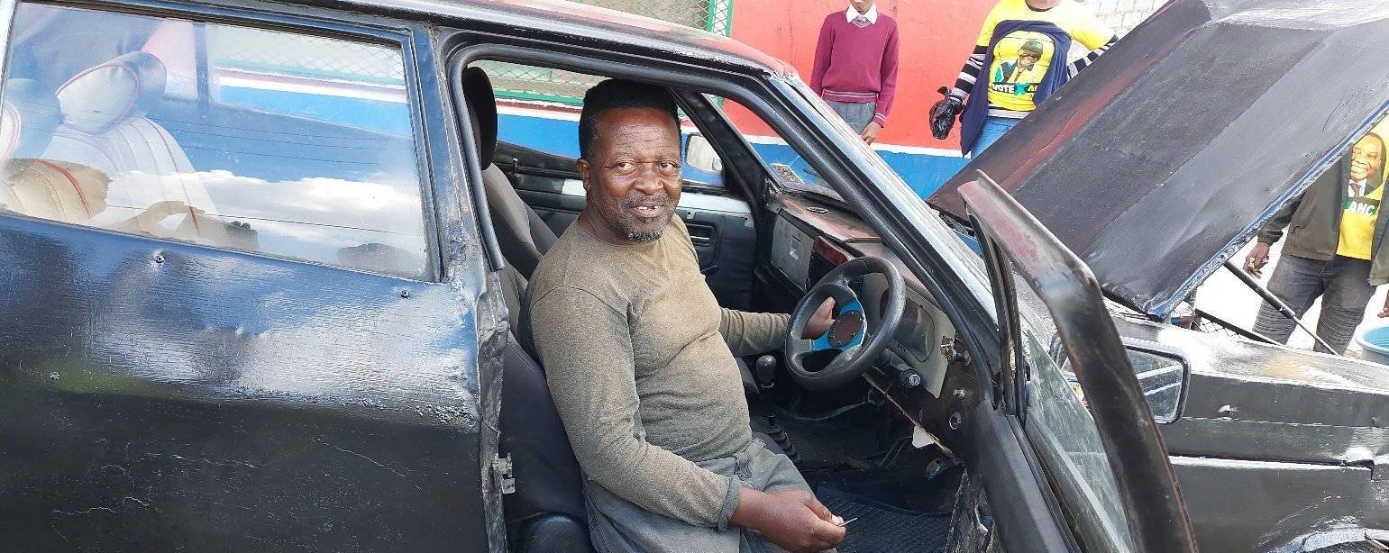 Car painter Mnqweno Nomgca sitting in his own car that he built. RIGHT:The car was built with scrap metal and a double bunk bed.         