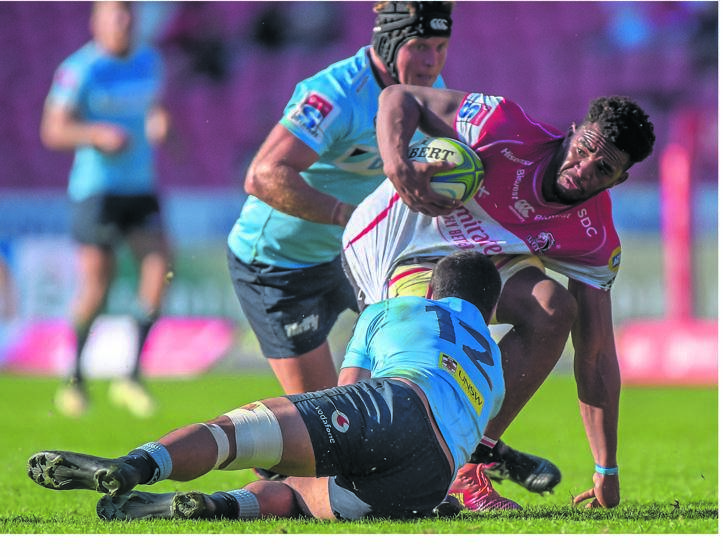 PILEUP Vincent Tshituka of the Lions is tackled by the Waratahs’ Karmichael Hunt during their Super Rugby match at Ellis Park Stadium yesterday  
