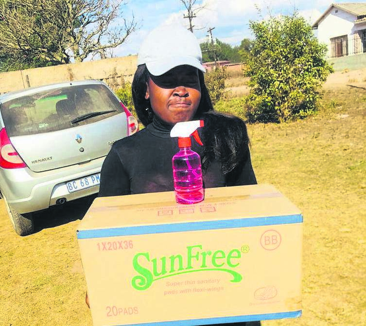 photo: andile sitholeFounder of Nurture The Future Foundation Philile Nzama distributes a pack of sanitary towels to young girls in Greytown. 