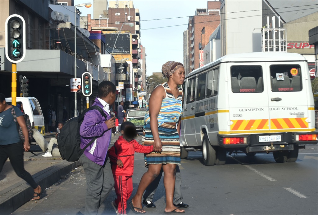 A mother helping her children cross the street Bru