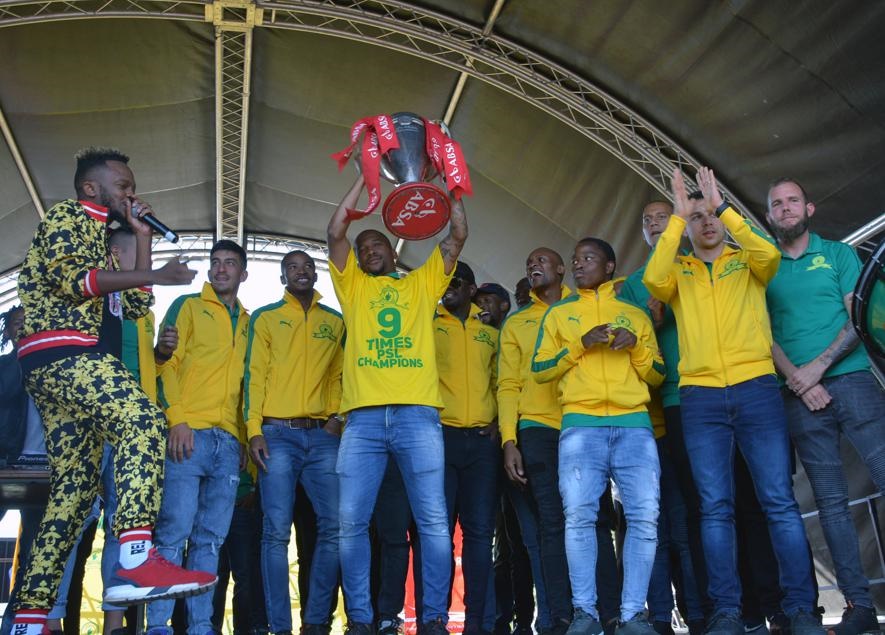 Sundowns players lift the cup for their fans while Kwesta continues to entertain. Photo by Morapedi Mashashe