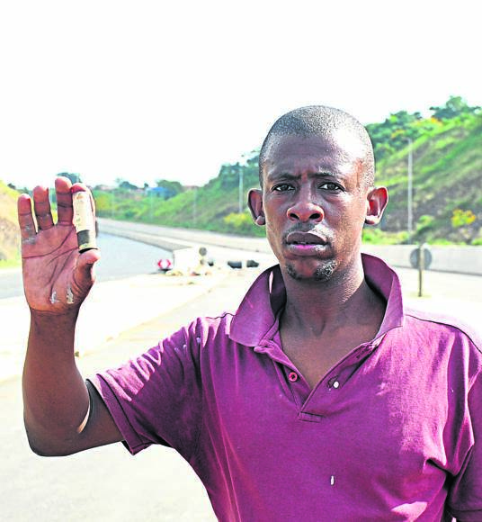Isishingishane member Nkanyiso Ndlela showing a bullet that was used by police to shoot them while they were demanding their money. Photo by 