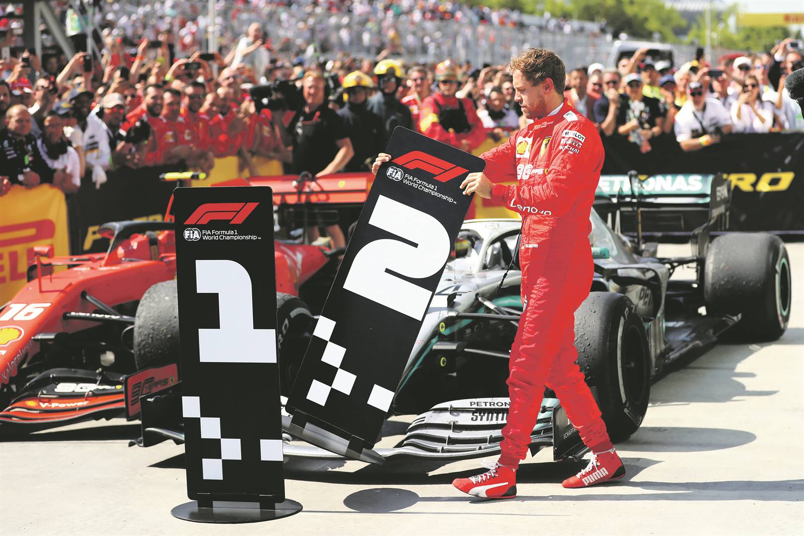 Second-placed Sebastian Vettel of Germany and Ferrari swaps the number boards at parc ferme during the F1 Grand Prix of Canada at Circuit Gilles Villeneuve last Sunday.Picture: Dan Istitene / Getty Images