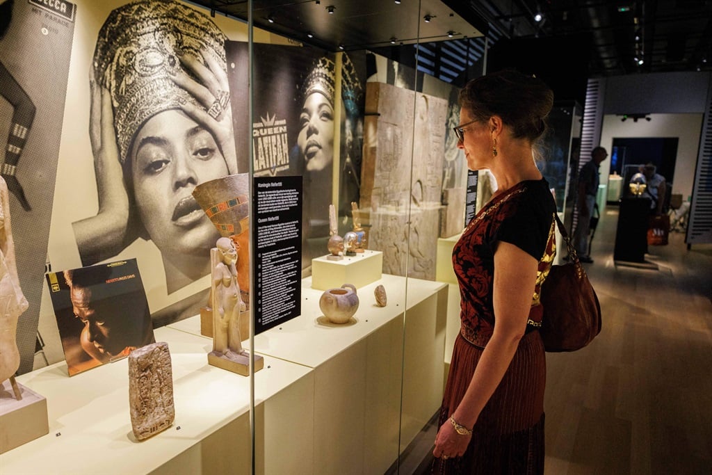 A visitor look on next to Hip-hop albums and sculptures displayed at the exhibition 'Kemet Egypt in hip-hop, jazz, soul & funk' of the Dutch National Museum of Antiquities (Rijksmuseum van Oudheden) in Leiden.