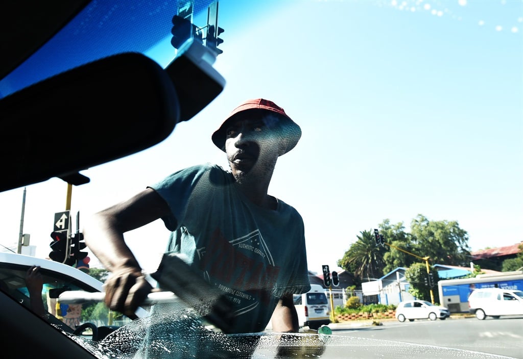 Intersection car window cleaning has become one of the best ways to ask for a penny or two in the streets of Gauteng. Photo by Morapedi Mashashe