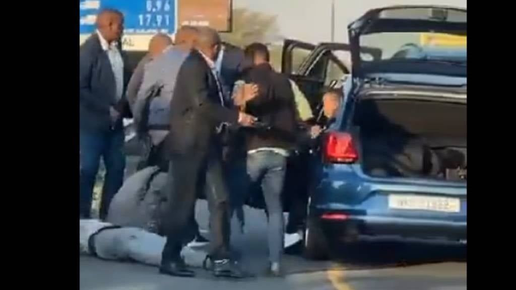 The VIP protection officers were captured on video dragging a man from a metallic blue VW and then kicking him as he lay on the ground in July 2023. (Screenshot)
