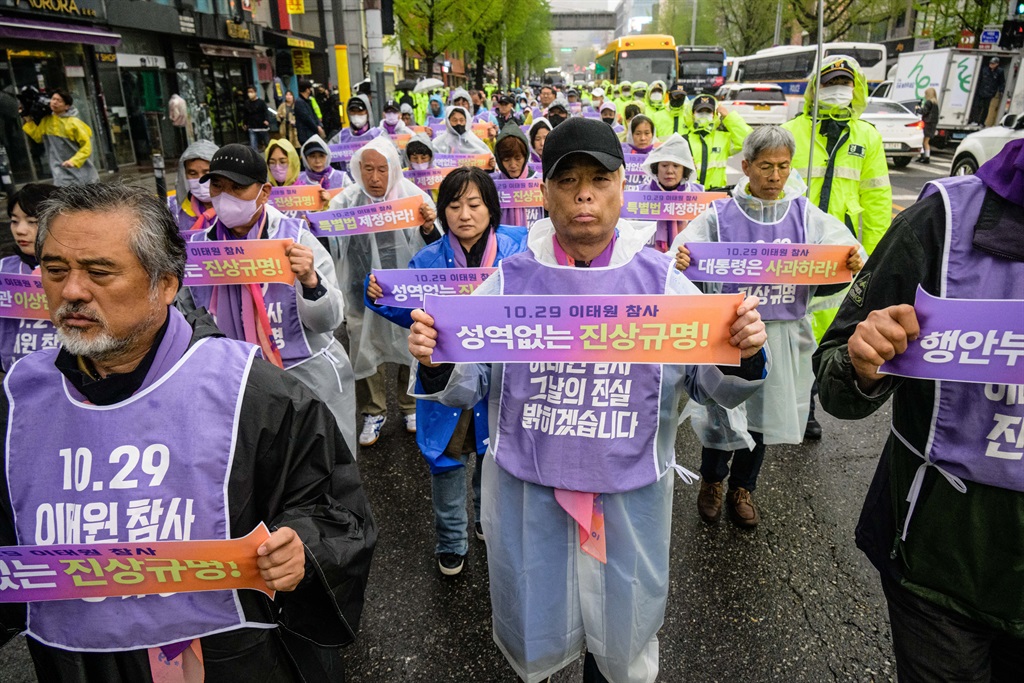 Families of the victims of a Halloween crowd crush in October last year march during a rally near the alleyway where the disaster took place in the popular Itaewon district of Seoul.