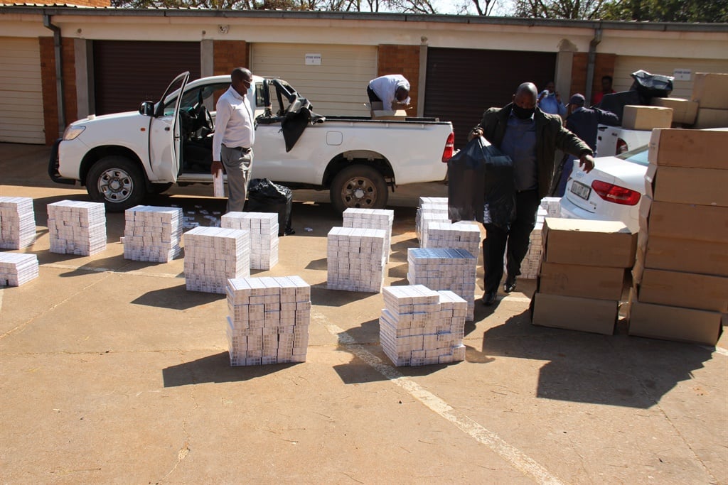 Members of the Hawks with the cigarettes seized in Mokopane. 