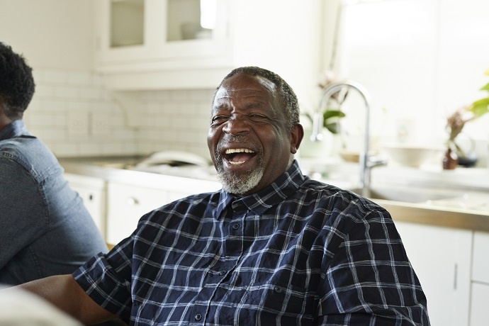 Happy senior man laughing while sitting at home.
