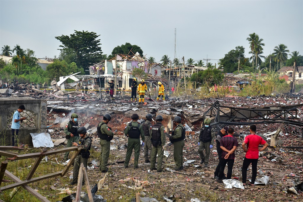 Thai police and firefighters work around destroyed
