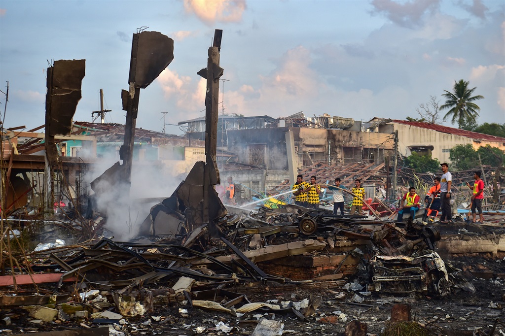 Thai firefighters put out embers around destroyed homes after an explosion ripped through a firework warehouse, killing nine people and injuring more than 100, in Sungai Kolok district in the southern Thai province of Narathiwat on July 29, 2023.
Madaree TOHLALA / AFP