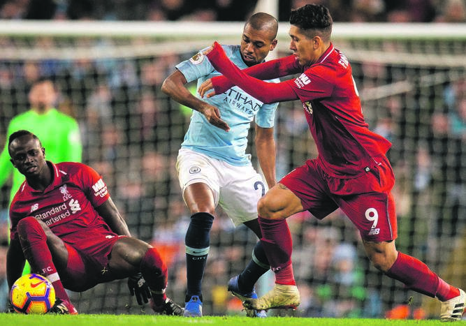 Manchester City’s Fernandinho in action against Liverpool’s Roberto Firmino as Sadio Mane; looks on during a Premier League match earlier this year. Picture: Peter Powell / EPA