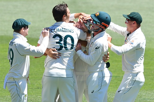 Steve Smith, Pat Cummins  ,Travis Head and Marnus Labuschagne of Australia hug Cameron Green of Australia after he caught Virat Kohli (Captain) of India during day three of the First Test match between Australia and India at Adelaide Oval on December 19, 2020 in Adelaide, Australia.