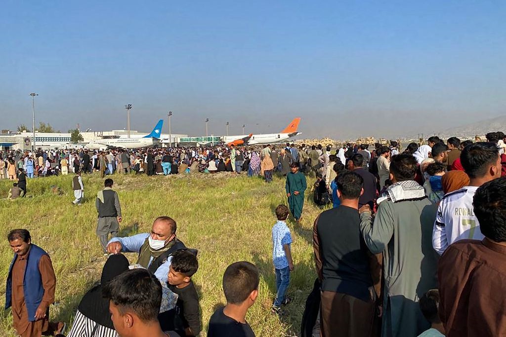 Afghans crowd at the airport as they wait to leave