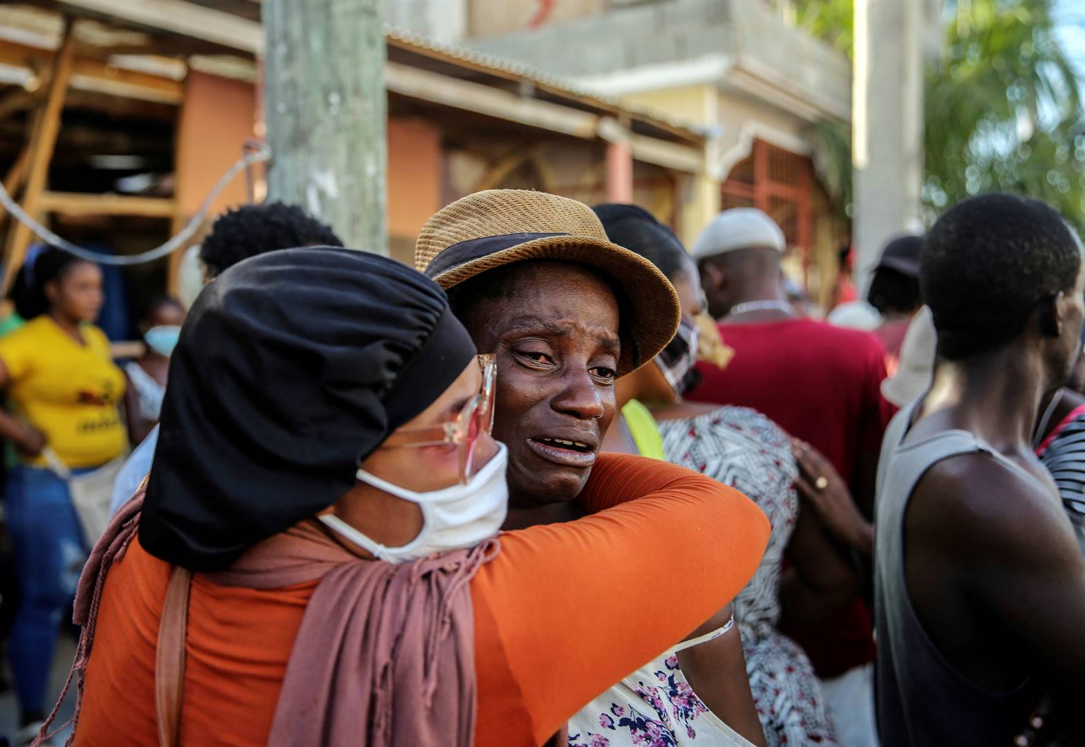 Mense huil Sondag gedurende die soektog na vermiste mense in ’n gebou in Les Cayes in Haïti. Foto: AP/Joseph Odelyn