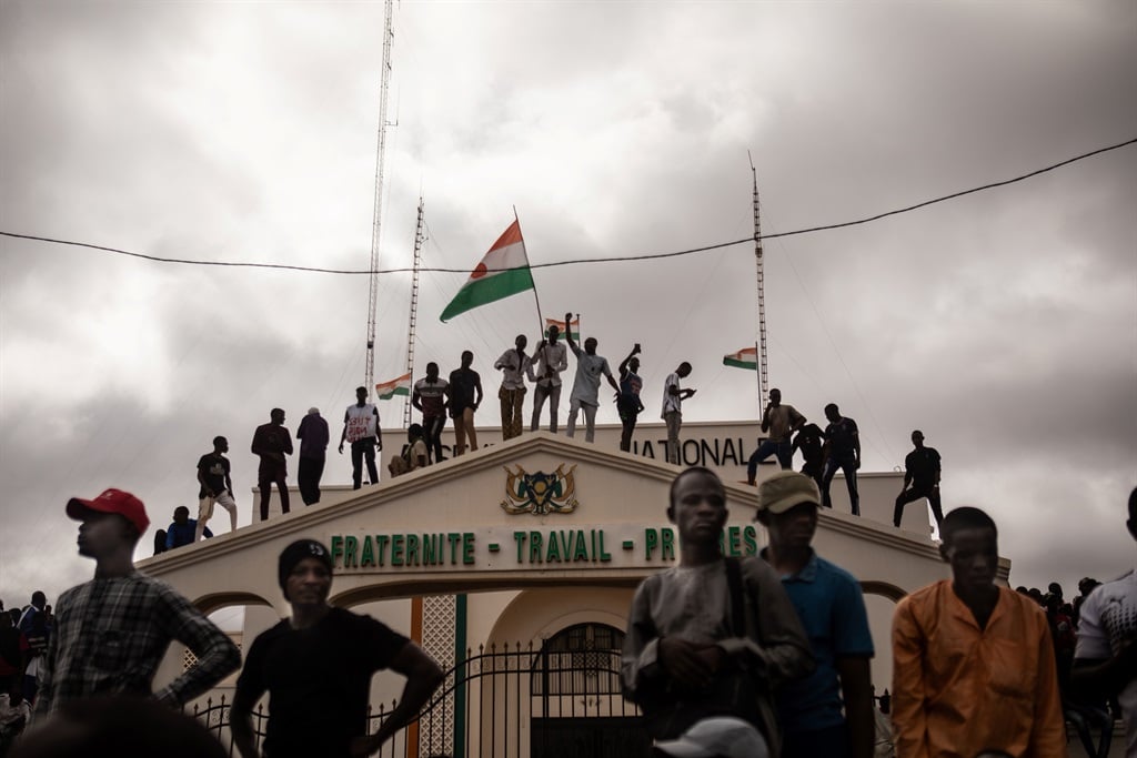  Protesters hold a Niger flag during a demonstration on independence day in Niamey on August 3, 2023. Hundreds of people backing the coup in Niger gathered on 3 August 2023 for a mass rally in the capital Niamey with some brandishing giant Russian flags.