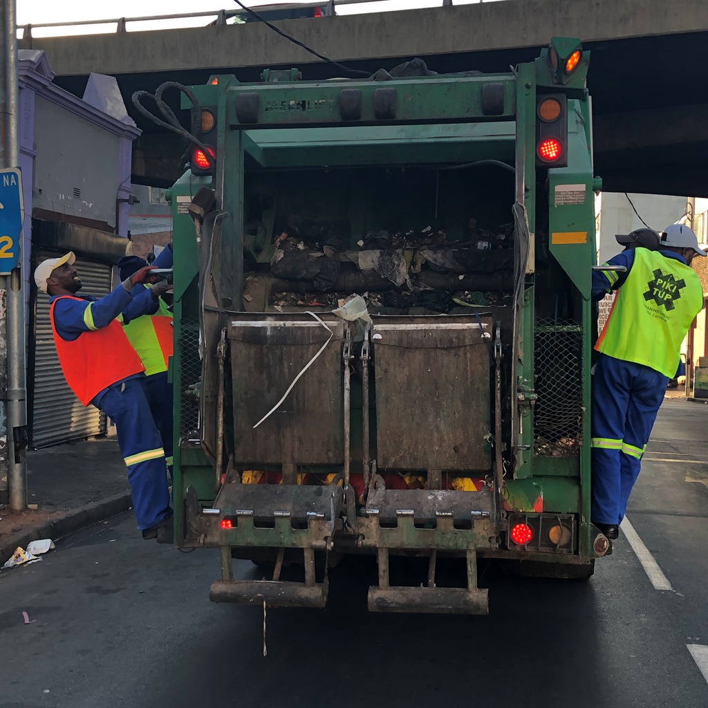 Pick up game: The Pikitup street team jumps on and off the truck loading bins on to the back with well rehearsed tactics. 
Pictures: Phumlani S Langa