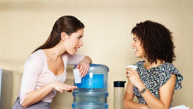 Two woman gossiping at the office watercooler. 
(Photo: Getty Images)