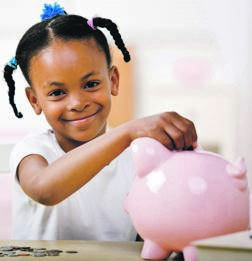 A responsible girl puts money into a piggy bank for the future.