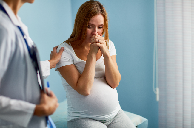 Pregnant woman crying with her doctor near by (Photo: Getty/Gallo Images)