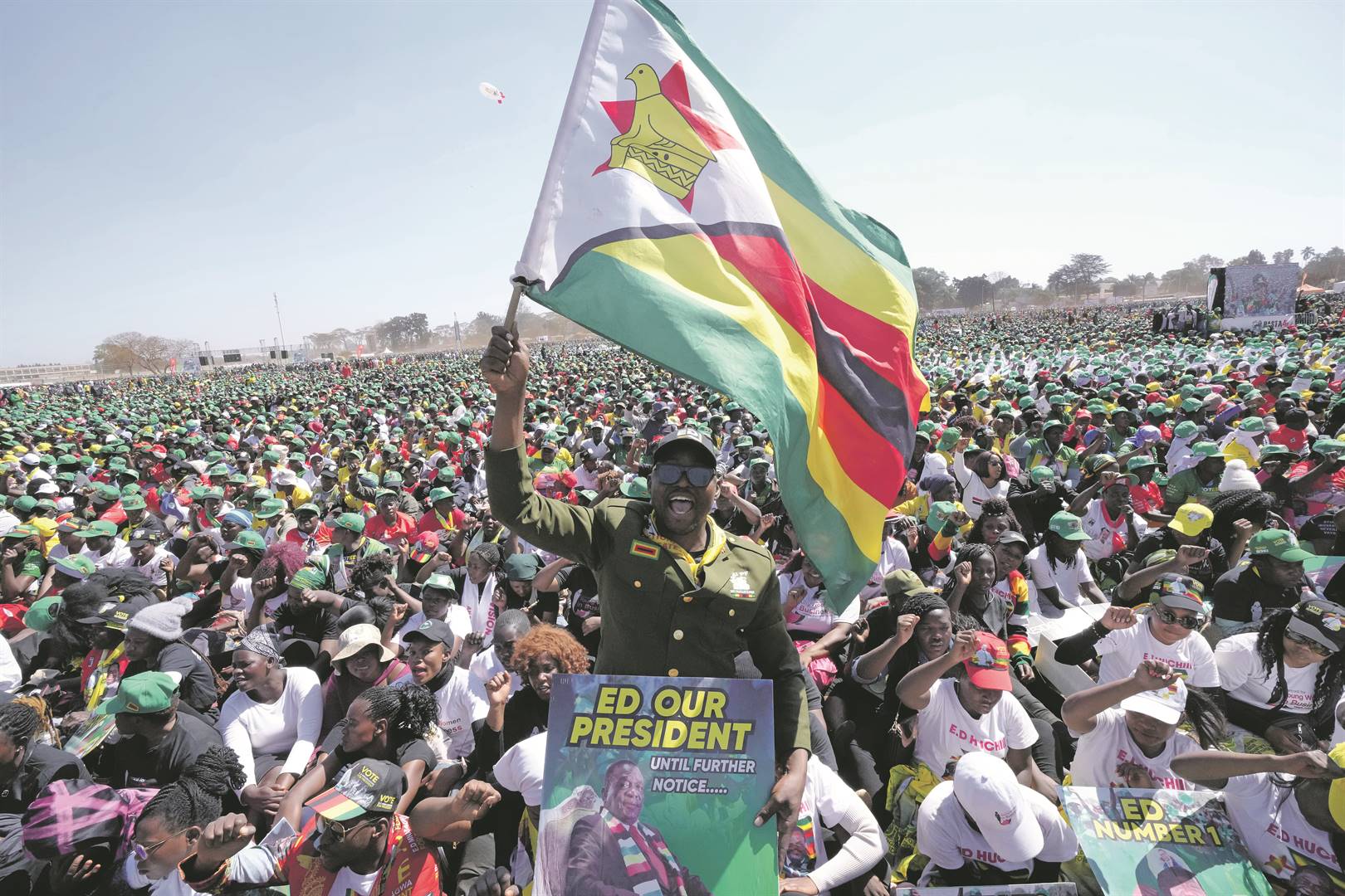 A supporter of Zimbabwean President Emmerson Mnangagwa holds the Zimbabwean flag at a campaign rally in Harare