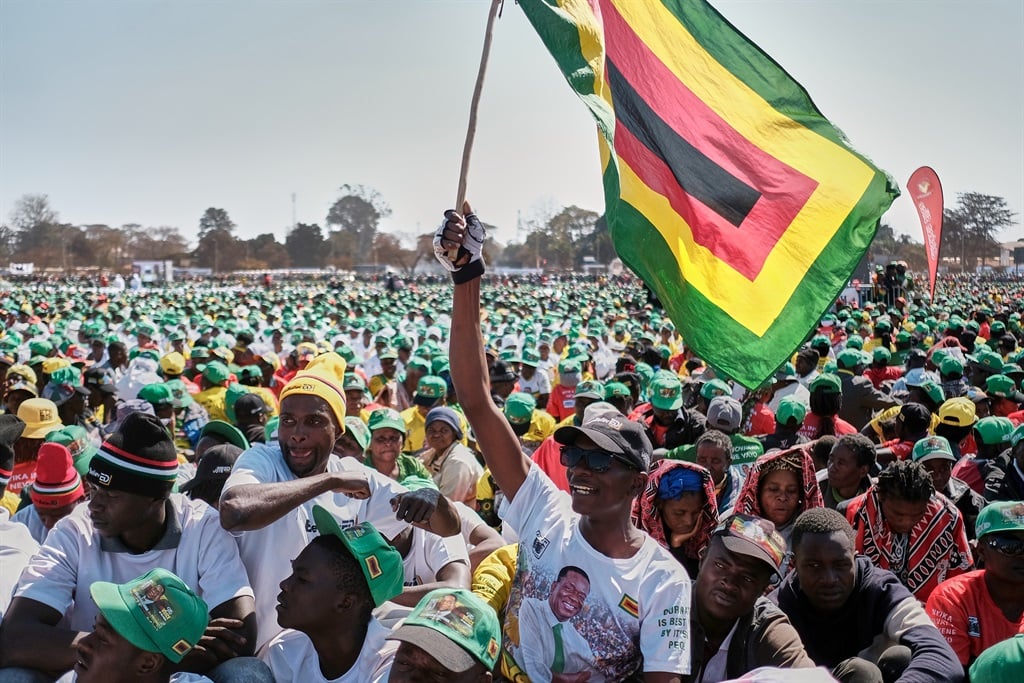 Supporters of Zimbabwe's ruling party ZANU PF wave their party flag during a rally addressed by party president Emmerson Mnangagwa, in Harare on 9 August 2023.