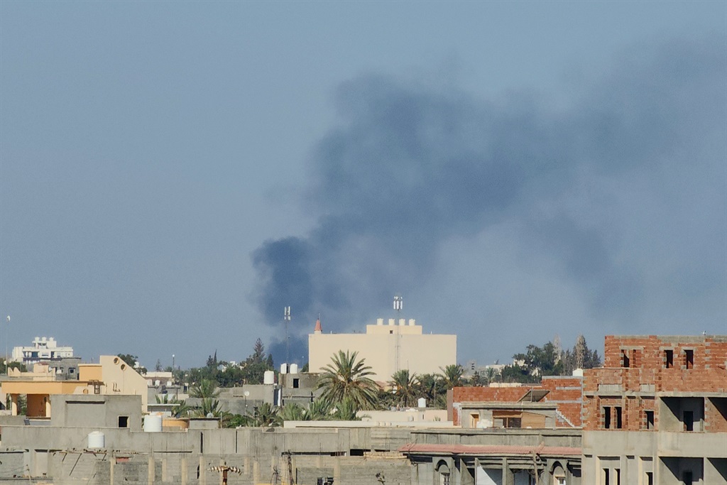 Smoke billows amid clashes between armed groups affiliated with Libya's Tripoli-based Government of National Unity (GNU) in the Libyan capital on 15 August 2023.