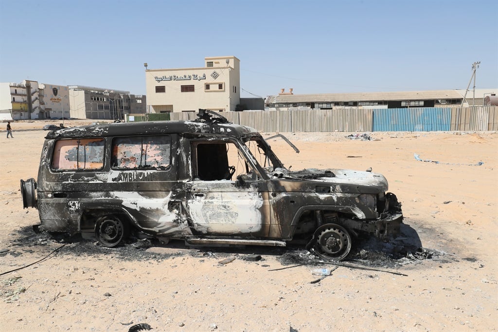 The carcass of a burnt car is pictured following two days of deadly clashes between two rival groups in Libya's capital, on 16 August 2023. Gun battles between two leading armed groups in Tripoli have killed 27 people and wounded 106, a toll update from the Emergency Medicine Centre said on 16 August.