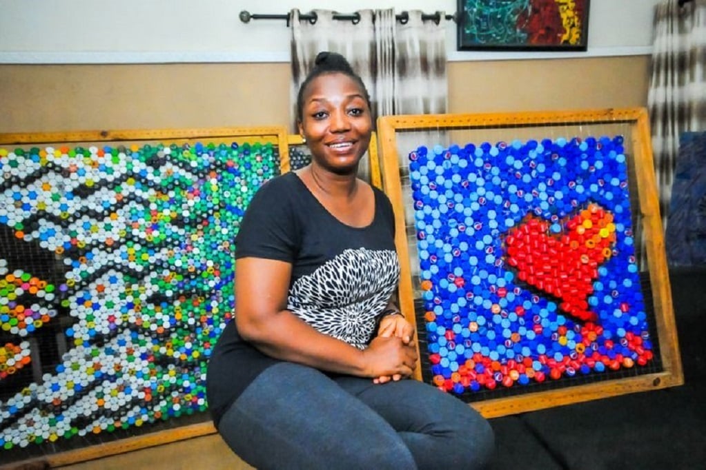 Olufunke Ojukwu posing with some pieces of art that she made from bottle caps. 