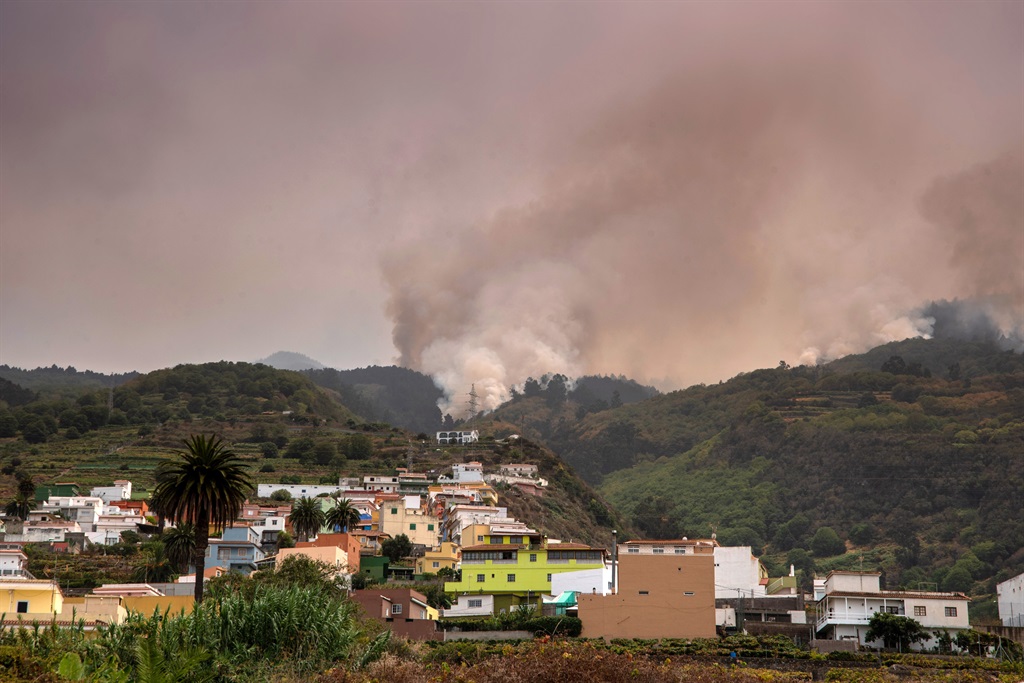 A wildfire rages out of control through forested s