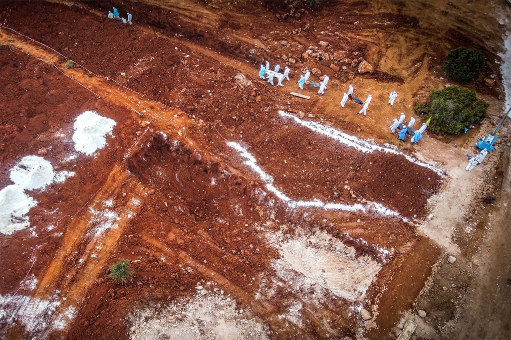 Volunteers bury bodies in a mass grave in the south of Derna. Thousands of people died in the Libyan city after flash flooding triggered by Storm Daniel led to the collapse of two dams. 
