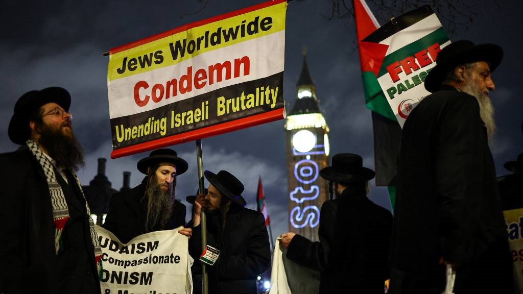 Members of the Ultra-Orthodox Jewish community hold placards as they protest in Parliament Square in London on 21 February 2024, during an Opposition Day motion in the House of Commons calling for an immediate ceasefire in Gaza. 