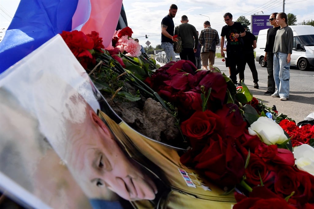 A portrait of Yevgeny Prigozhin is seen amid flowers at a makeshift memorial in front of the Wagner Centre in Saint Petersburg.