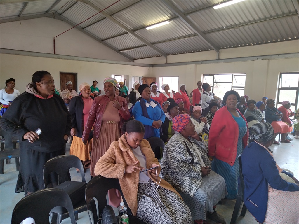Women gathered at a hall to pray during their women’s prayer event after a local cop was killed. Photo by Xolile Nkosi