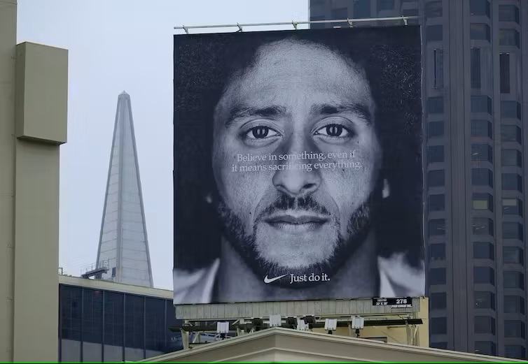A large billboard featuring Colin Kaepernick stands on top of a Nike store at Union Square in San Francisco. 