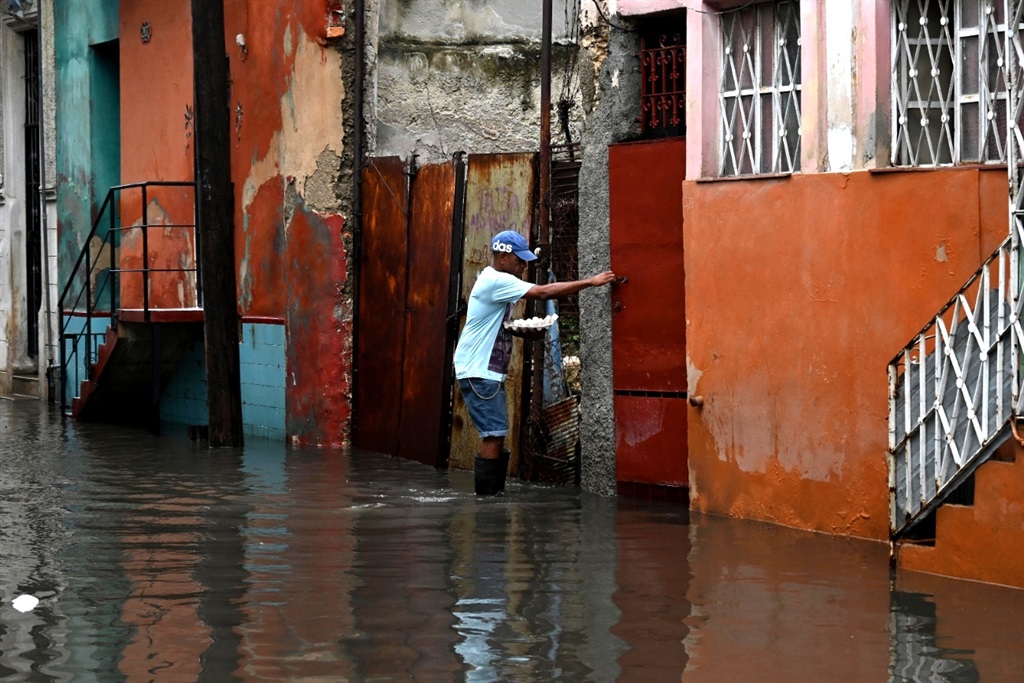A man walks through a flooded street in Havana, on