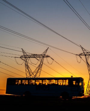 A bus passes power lines at dusk. (iStock)