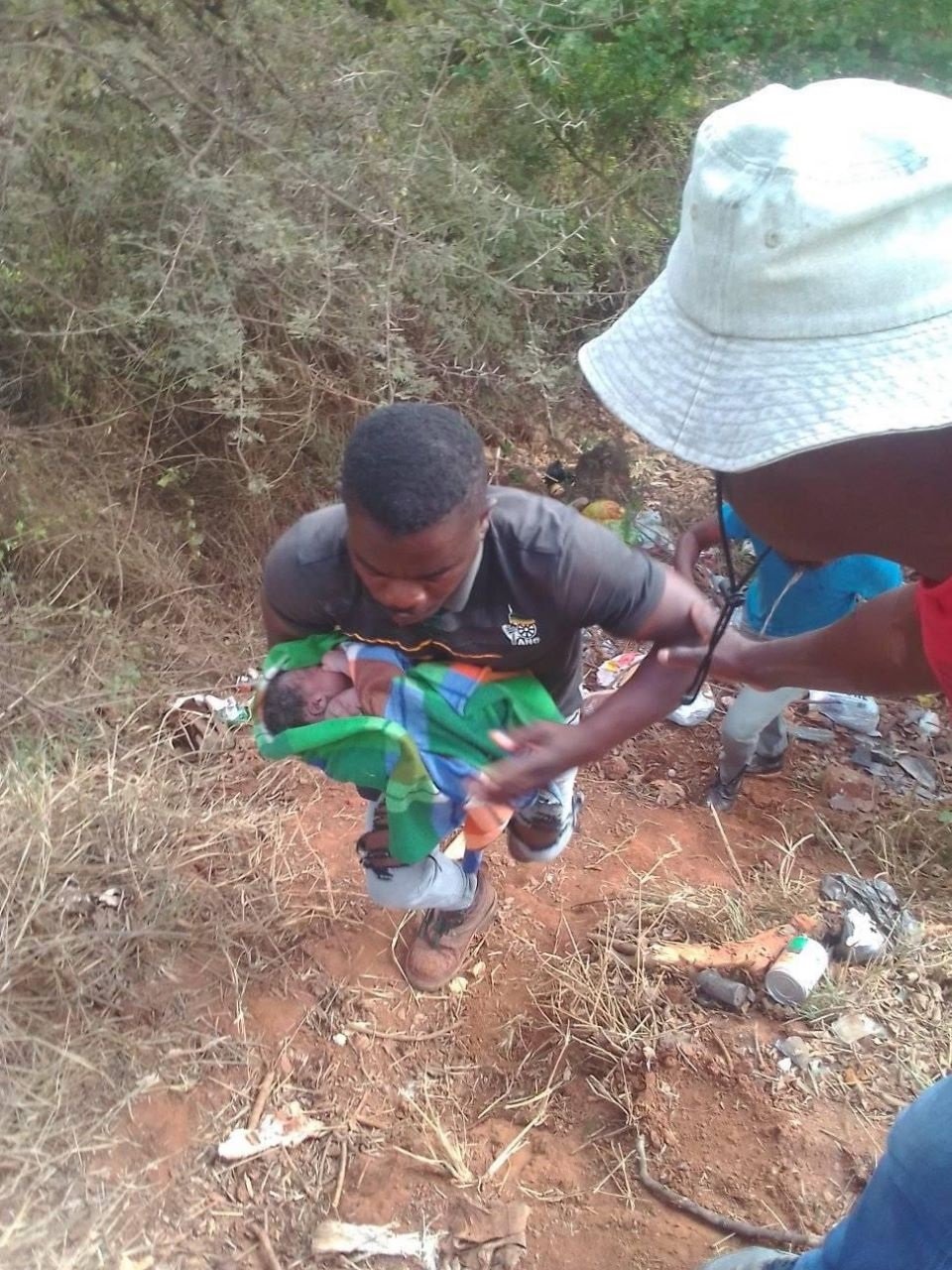 Resident Eddie Malatji with a newborn baby found dumped at a dumping site.