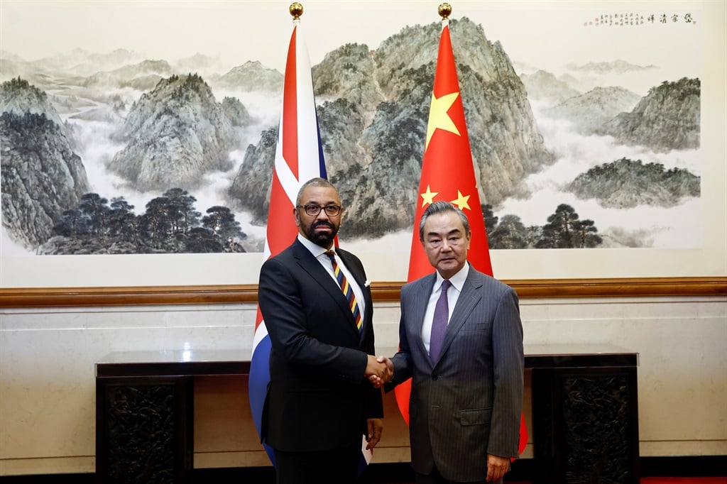 British Foreign Secretary James Cleverly (L) and Chinese Foreign Minister Wang Yi shake hands before a meeting at the Diaoyutai State Guesthouse in Beijing on 30 August 2023.