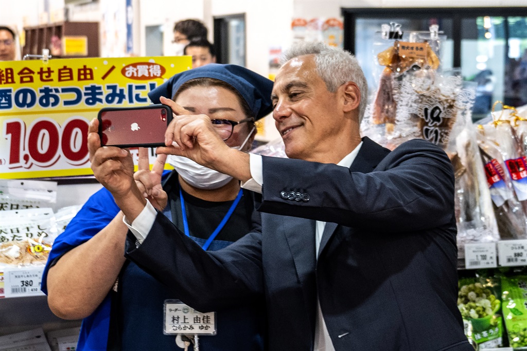 US Ambassador to Japan Rahm Emanuel (R) poses for a selfie with a worker during his visit to Hamanoeki Fish Market and Food Court, as part of his trip to Soma City in Fukushima Prefecture on 31 August 2023. (Photo by Philip FONG / AFP)