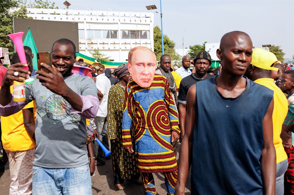A supporter of Mali's interim president wears a face mask of the President of Russia, Vladimir Putin, during a pro-Junta and pro-Russia rally in Bamako on 13 May 2022. (Photo by OUSMANE MAKAVELI / AFP)