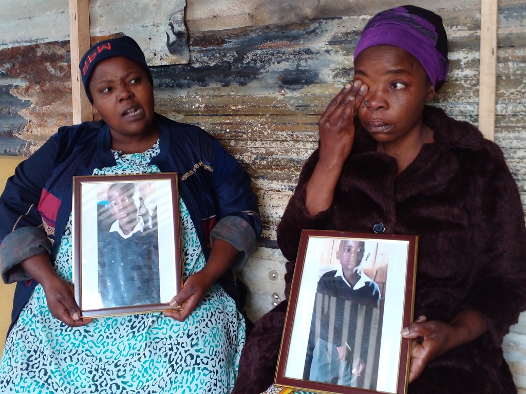 Mom's twin Zoleka Velengceni with their aunt Ntombi Velengceni holding pictures of the seven-year-old twins who died in a shack fire along with their dad in Covid squatter camp in Cape Town: Photos By Lulekwa Mbadamane

