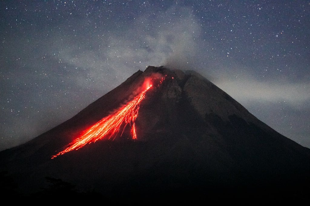 In this picture taken on August 9, 2023, Mount Merapi spews lava onto its slopes during an effusive eruption as seen from Wonokerto village, Yogyakarta. 
