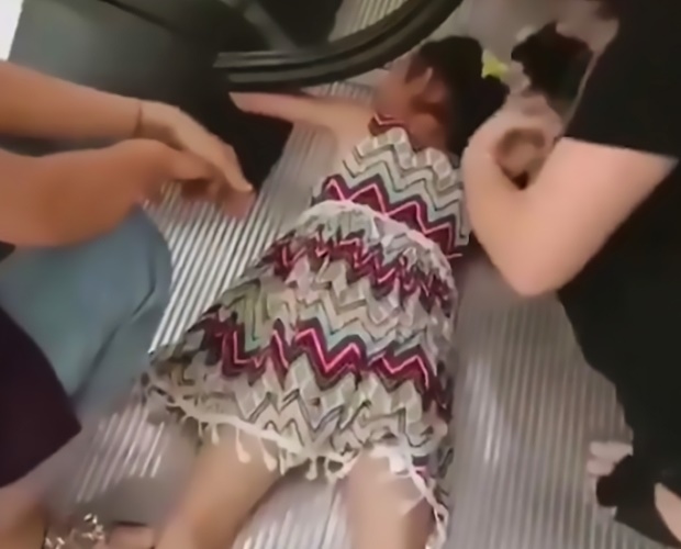 Girl's hand gets sucked in by escalator. (Photo: 