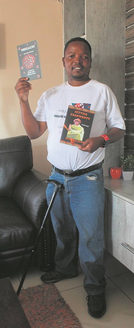 Sivuyile Qeqe displays two of his books of poems.         