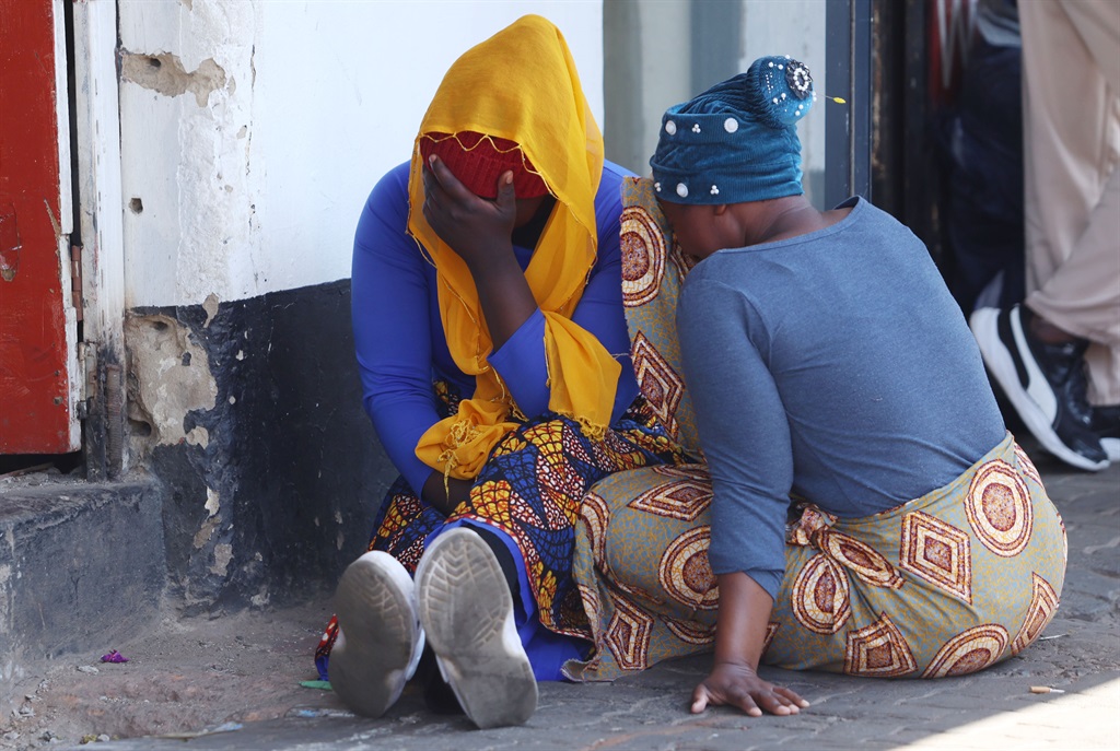 Emotional relatives of the deceased near the 80 Albert Street building on 31 August in Johannesburg. 
